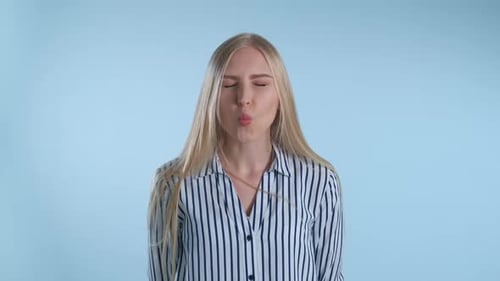 Femme joyeuse faisant des visages drôles sur fond bleu
