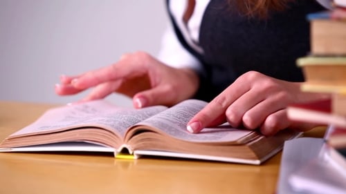 Caucasian Female College Student Reading Book in Library