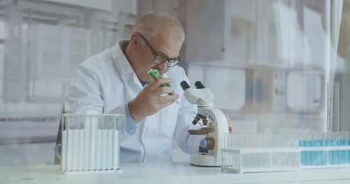 Male Research Scientist. He Sitting in a High-End Modern Laboratory with Beakers, Glassware