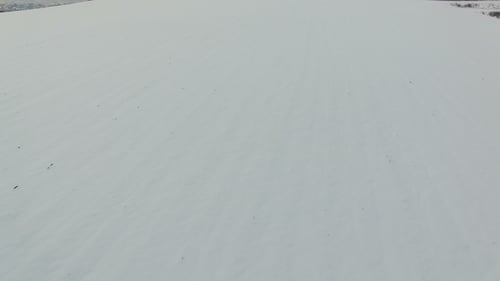 Fliegen Sie mit dem fahrenden LKW über ein schneebedecktes Feld auf die Straße.