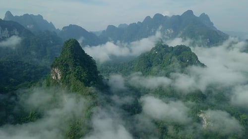 Limestone Rocks in Mist Covered with Lush Tropical Greenery. Top View of Mountains in