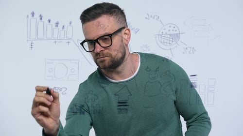 Man Draws Various Growth Charts, Calculating Prospects for Success in a Modern Glass Office