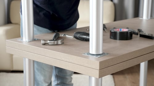 Man Assembling Wooden Table with Metal Legs