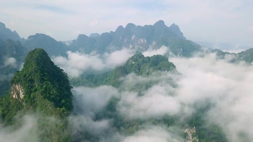 Blick auf Kalksteinfelsen im Nebel, bedeckt mit üppigem tropischem Grün. Blick von oben auf die Berge