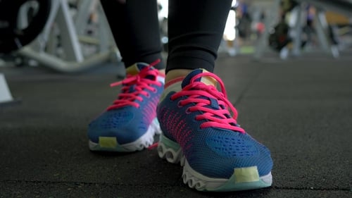 Running Shoes - Woman Tying Shoe Laces in the Gym