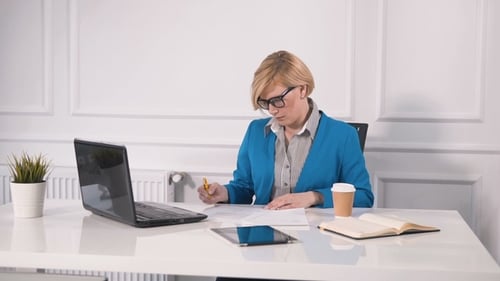 Woman Working at Desk with Computer and Tablet