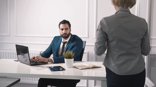 Woman Brings Coffee to Man Working in Office