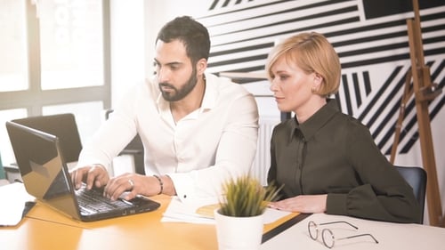 Colleagues Working on Laptop in Modern Office