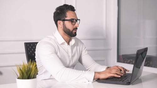 Man Working on Laptop in Modern Office