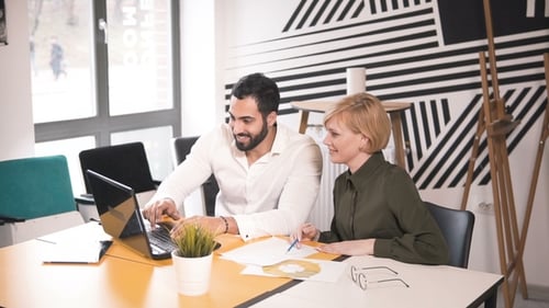 Man and Woman Celebrate Success at Office Desk