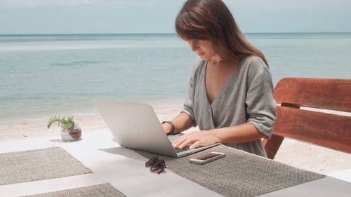 Young Woman Works on Laptop in Outdoor Cafe