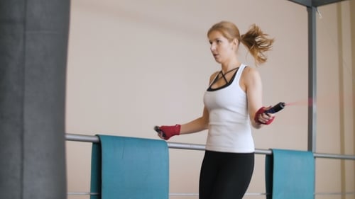 Beautiful Athletic Woman Exercising Jumping Rope in The Gym