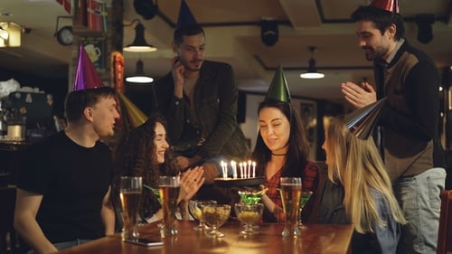 Friends Celebrating Birthday with Cake and Party Hats