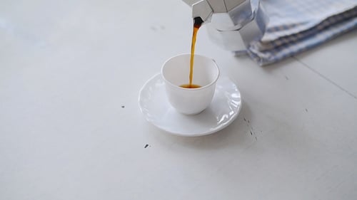 Coffee Being Poured into a White Cup