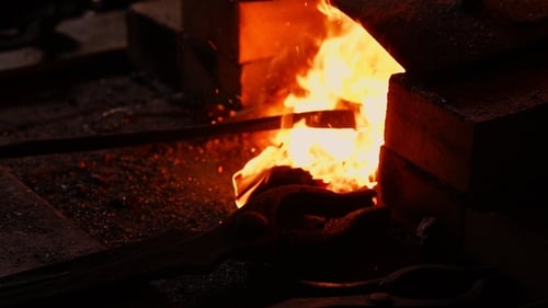 Blacksmith Tending to Blazing Hot Industrial Furnace