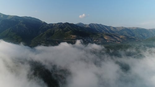 Luftbild. In Wolken über die wunderschöne Bergküste fliegen