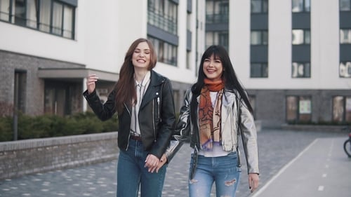 Cheerful Girls Walk Around the Spring City, Laugh, Smile and Hug