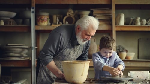 Grandfather Teaching Pottery to Child in Workshop