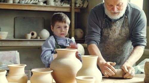 Potter and Boy Working with Clay in Studio