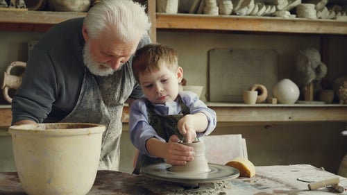 Child Making Pottery with Adult Guidance