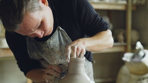 Shot of Young Potter Formkeramikvase aus Ton auf Wurfrad