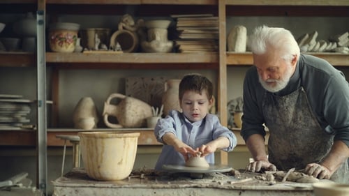 Child Learning Pottery with Grandfather
