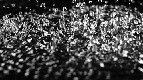 Starke Vibration hebt die Wassertropfen an. Schwarzer Hintergrund. Starke Vibration hebt die Wassertropfen an. Schwarzer Hintergrund.