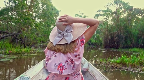 Female Tourist in Hat Riding Boat on Thale Noi Waterfowl Reserve Lake