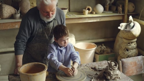 Boy Learning Pottery Making With Adult Assistance