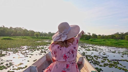 Female Tourist in Hat Riding Boat. Young Woman Visiting Thale Noi Waterfowl Reserve Lake, Thailand