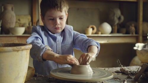 Boy Creates Clay Pottery on a Wheel