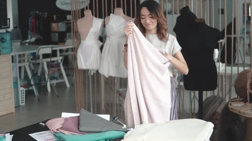 Girl Designer Clothes Makes Sketches on Paper. Young Woman Working in a Sewing Studio