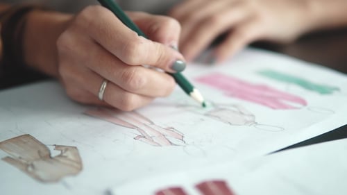 Fashion Designer Sketches Artwork with Colored Pencil