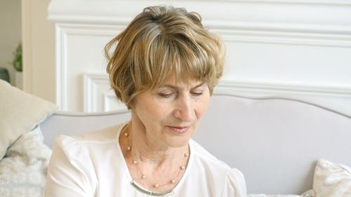 Senior Woman Relaxing on Gray Couch