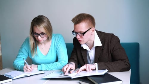 Porträt zweier erfolgreicher Schüler Casual Stylish, Jungen und Mädchen im Lesesaal der Bibliothek, Abend