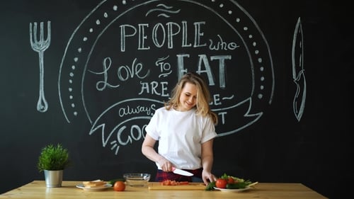 Smiling Woman Dicing Tomatoes in Bright Kitchen