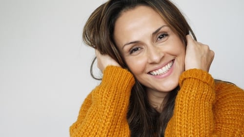 Woman Smiling and Posing in Orange Sweater