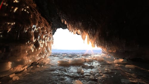 Ice Cave with Icicles at Sunset at Winter Baikal