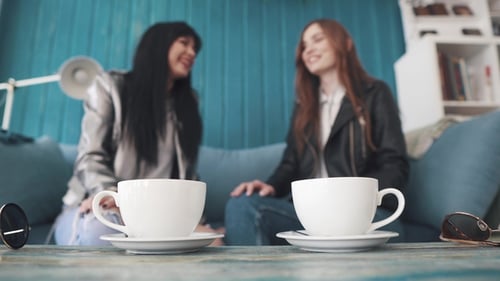 Kaffeetassen. Mädchen nehmen Tassen und trinken gleichzeitig