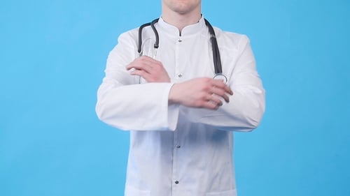 Smiling Young Doctor in White Uniform Looking at Camera