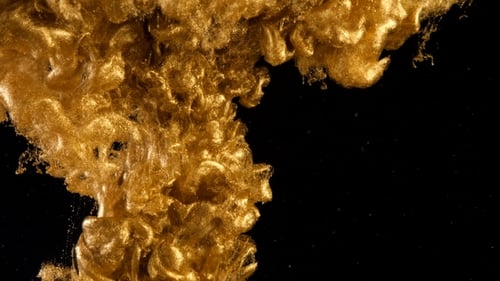 Tinte in Wasser. Farbe: Goldene Glitzerfarbe, die im Wasser reagiert und abstrakte Wolkenformationen erzeugt.