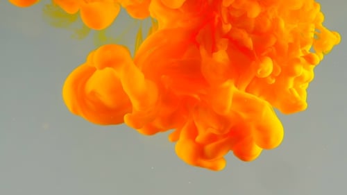 Vibrant Orange and Yellow Ink Mixing in Water