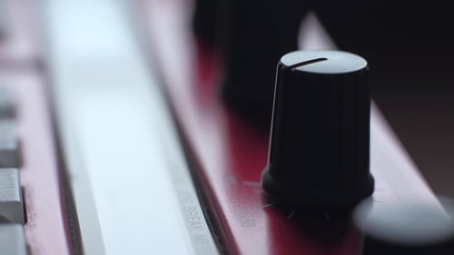 Hand Adjusting Knob on Music Synthesizer