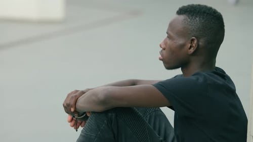 Jeune migrant africain seul et déprimé seul dans la ville