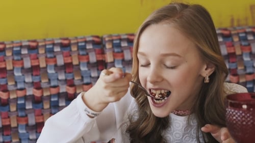 Girl Enjoying Slice of Cake Indoors