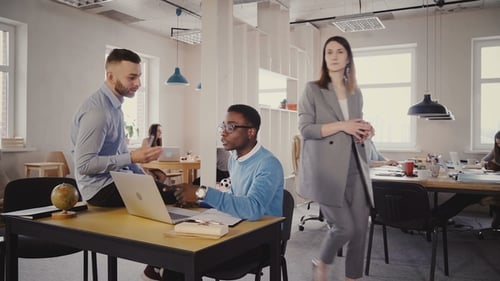 Two Young Multiethnic Casual Colleagues Work Together in Trendy Loft Office Space, European Female