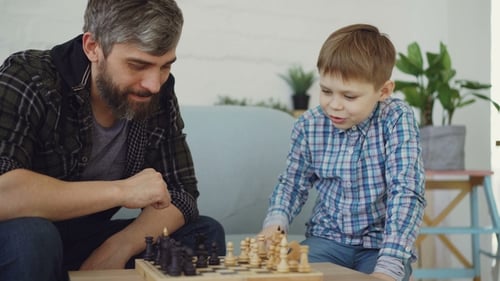 Loving Dad Is Playing Chess with His Little Child, Teaching Him Rules and Talking To Him