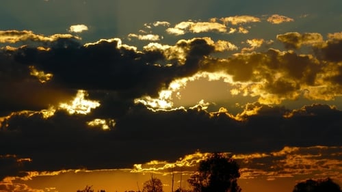 Dramatic Sunset Sky with Dark Clouds and Golden Sunlight