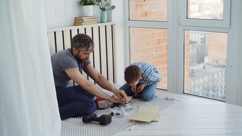 Urious Little Son and Loving Father Are Busy with Woodwork Working with Instruments and Driving