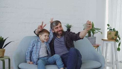 Father and Son Taking Fun Selfies on Couch